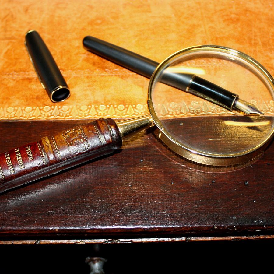Loupe et stylo posés sur une table